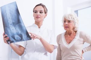 medic pacienta prezinta radiografia coloanei vertebrale